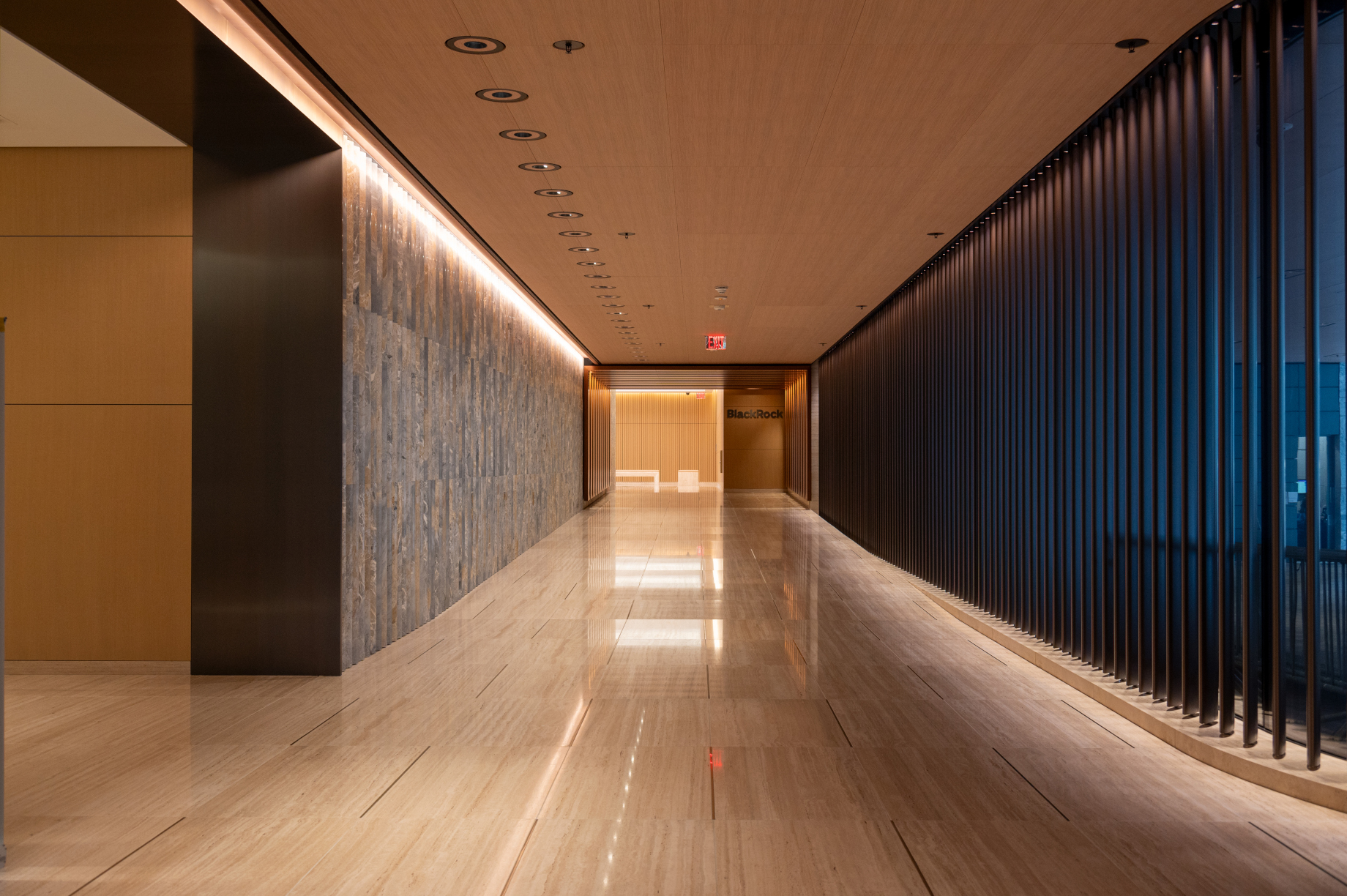 A hallway with a wood ceiling and wood floor finish